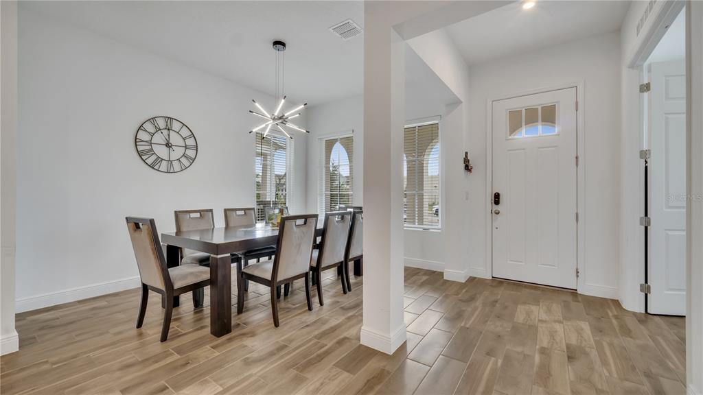 A dining room with a dark wood table, upholstered chairs, and wood-look tile flooring — 2069 CELEBRATION BOULEVARD, KISSIMMEE, FL