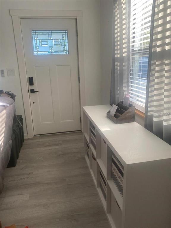 A white entryway features a front door with a decorative window and a storage unit — 1110 E EDGEWOOD DRIVE, LAKELAND, FL