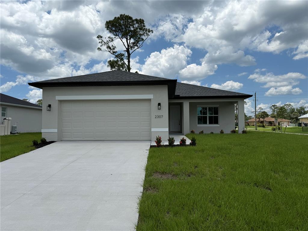 A single-story house with a concrete driveway, a two-car garage, and a covered entryway — 2307 ZUYDER TERRACE, NORTH PORT, FL