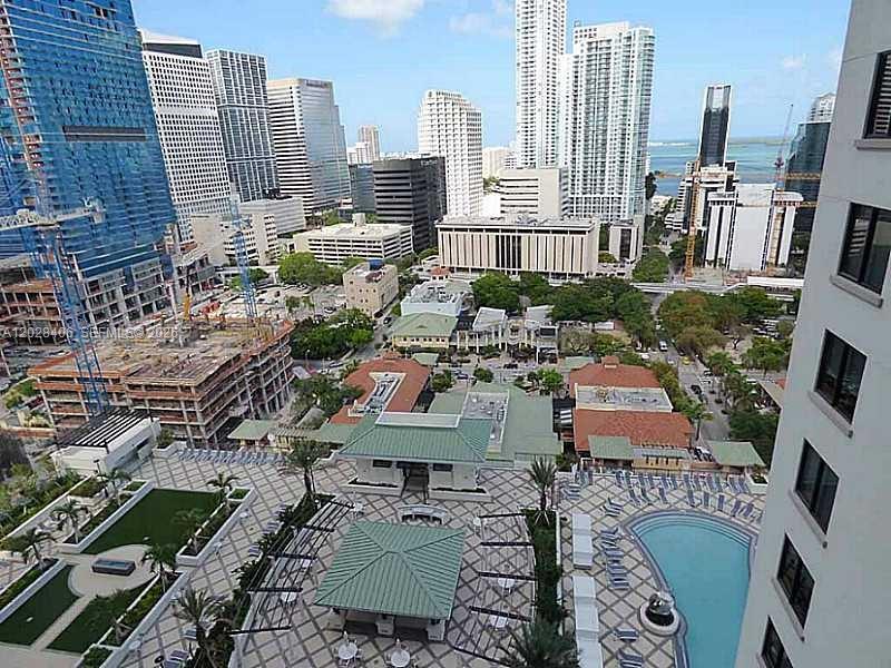 An elevated view shows a swimming pool, patio, and surrounding high-rise buildings in a city — 999 SW 1 AVE # 1907, Miami FL 33130, MIAMI, FL