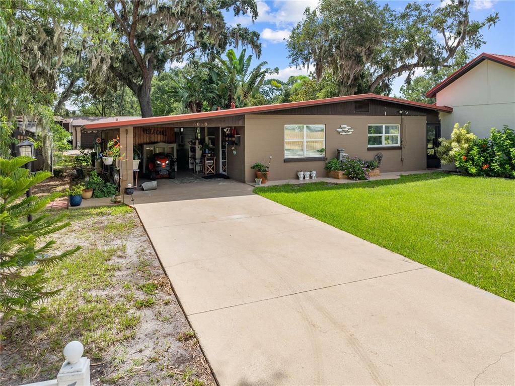 A single-story house with a brown exterior, a carport, and a concrete driveway — 5868 ALLIGATOR LAKE SHORE W, ST CLOUD, FL
