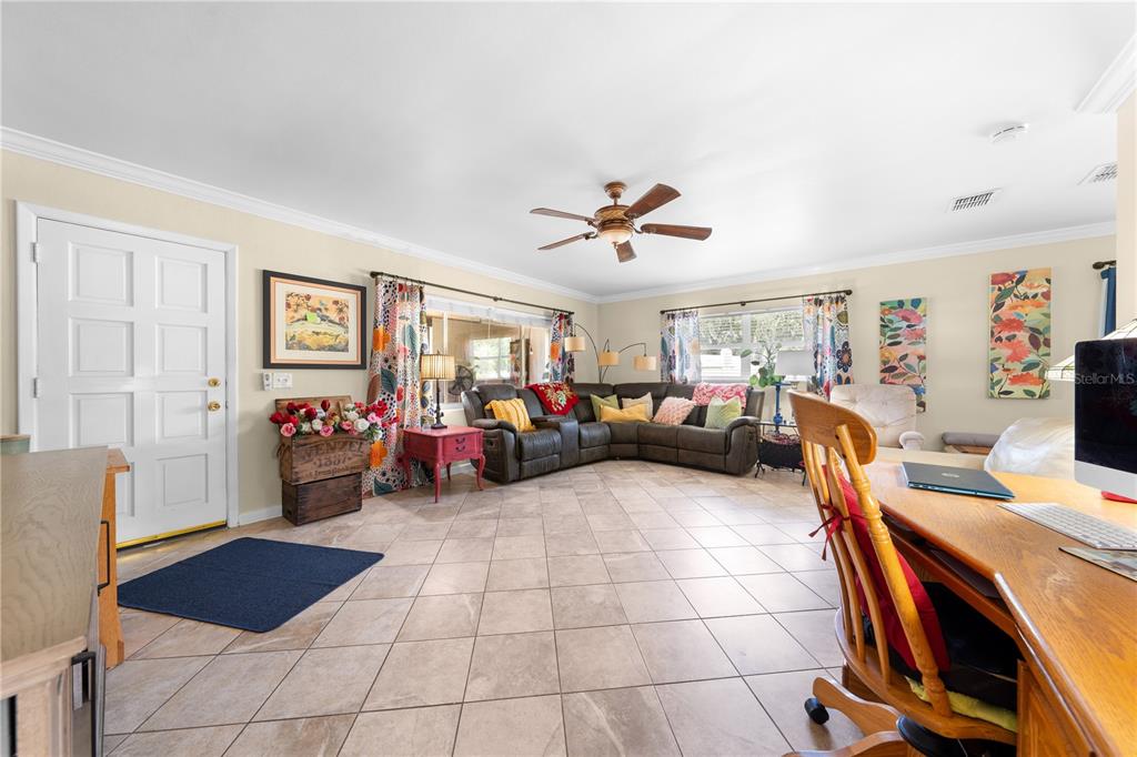 A living room features tile flooring, a sectional sofa, a ceiling fan, and a desk — 5868 ALLIGATOR LAKE SHORE W, ST CLOUD, FL