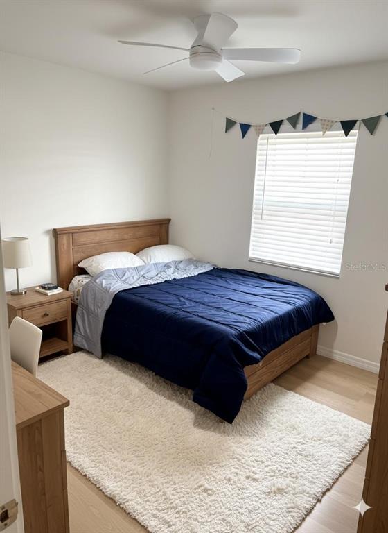 A bedroom features a wooden bed frame, a white rug, and a ceiling fan — 6016 18TH STREET NE, ST PETERSBURG, FL