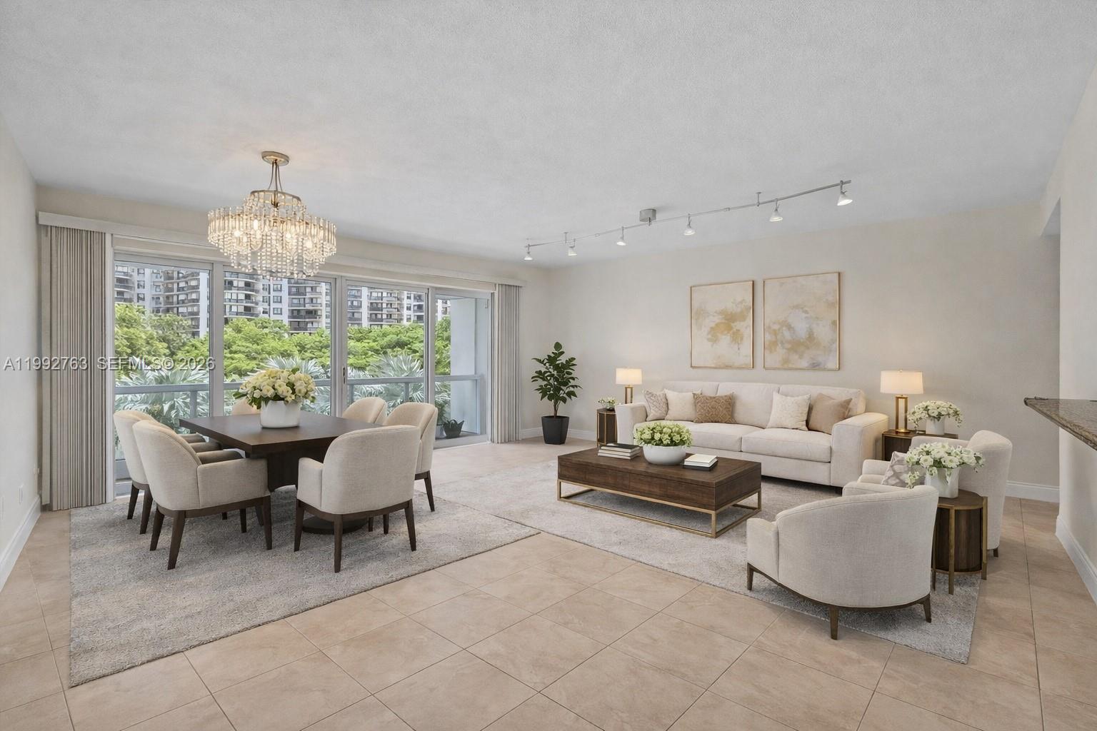 A bright, open-concept living and dining area features neutral furniture, tile floors, and large windows — 2451 Brickell Ave # 4F, Miami FL 33129, MIAMI, FL