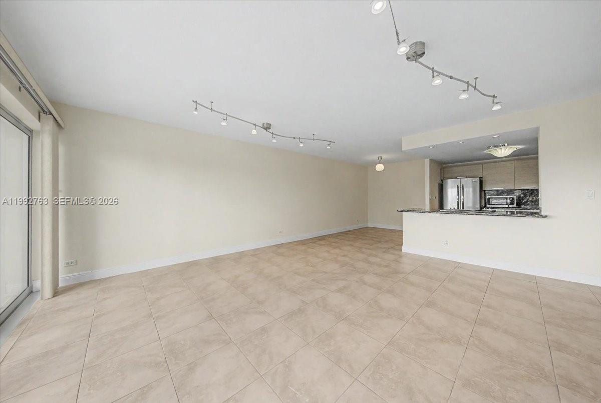 An open-concept living area features light-colored tile flooring and a kitchen with a breakfast bar — 2451 Brickell Ave # 4F, Miami FL 33129, MIAMI, FL