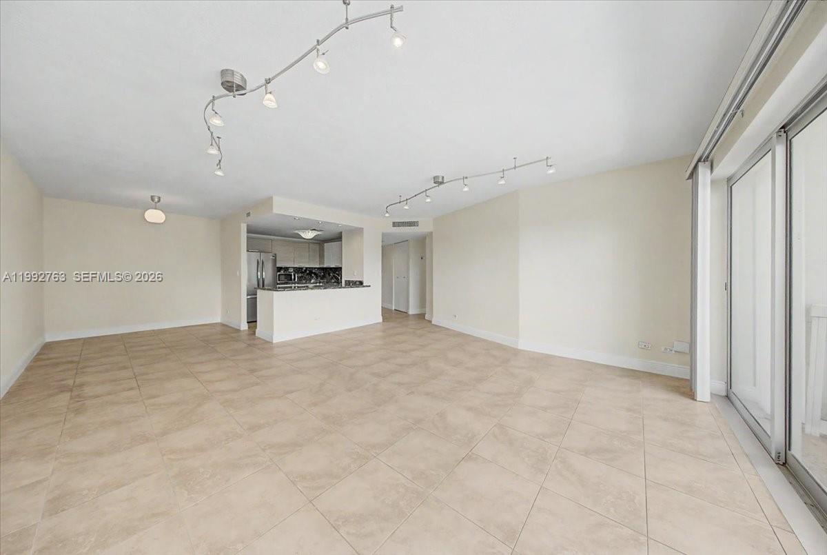 An open-concept living area features beige tile flooring, recessed track lighting, and a kitchen pass-through — 2451 Brickell Ave # 4F, Miami FL 33129, MIAMI, FL