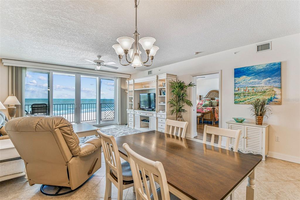 A dining area and living room with an ocean view through large sliding glass doors — 19710 GULF BOULEVARD UNIT 203, INDIAN SHORES, FL
