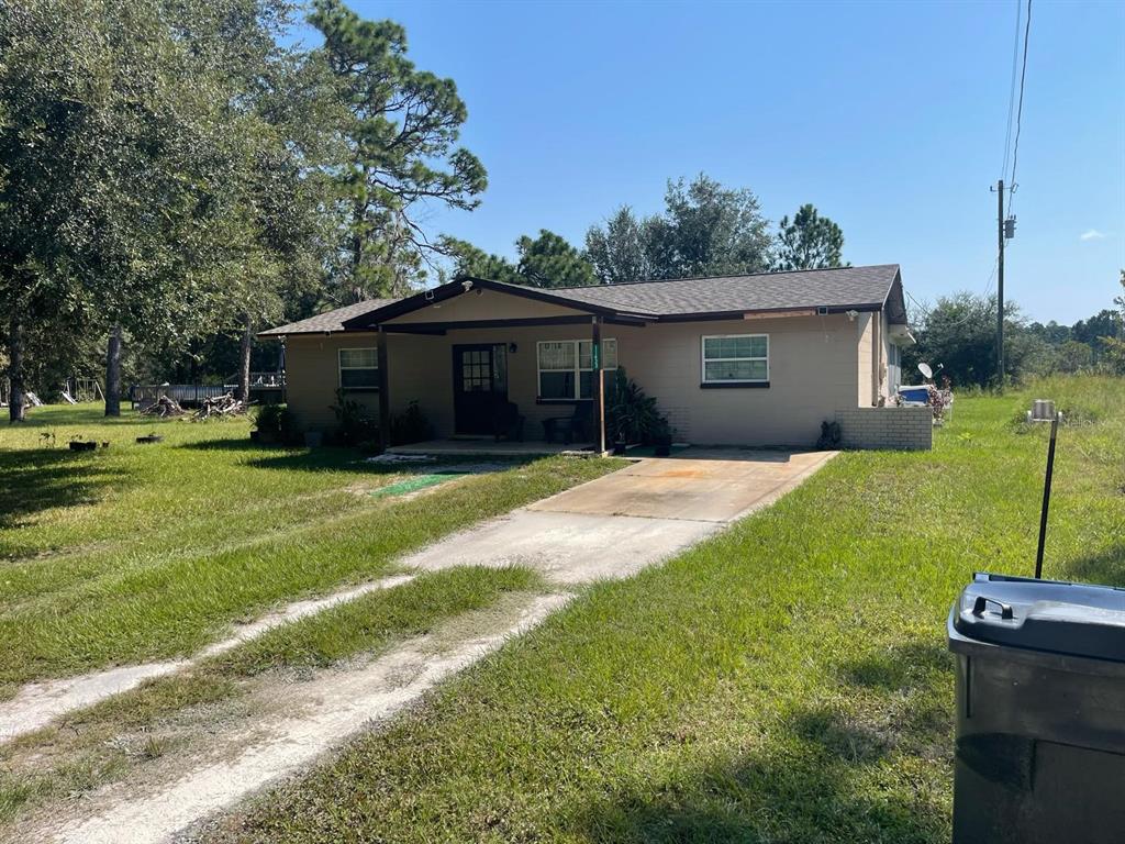 A single-story house with a covered front porch and a concrete driveway sits on grass — 11433 S ROSEWATER POINT, HOMOSASSA, FL