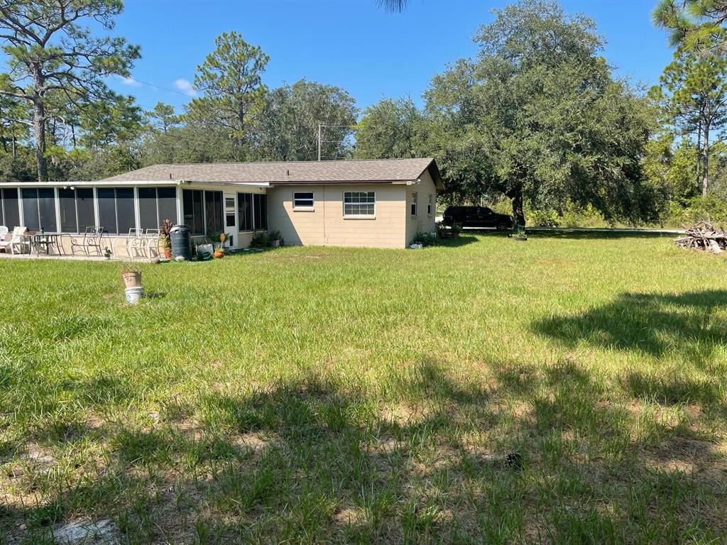 A single-story house with a screened-in porch sits on a large, grassy lot — 11433 S ROSEWATER POINT, HOMOSASSA, FL