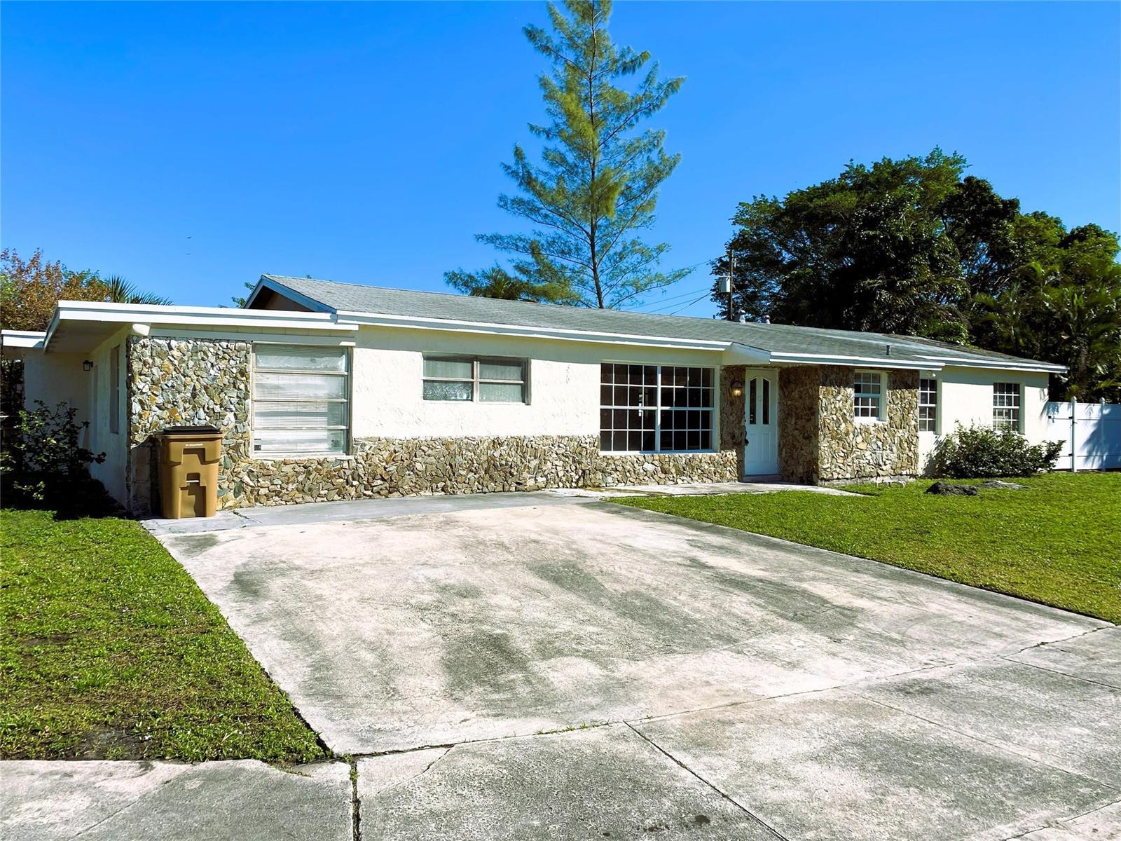 A single-story house features a stone facade, a concrete driveway, and a large front lawn — 320 NW 4th Avenue # 1, Deerfield Beach FL 33441, DEERFIELD BEACH, FL