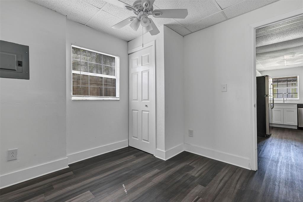 A room with dark wood-look flooring, a ceiling fan, a window, and a closet door — 2027 30TH AVENUE N Bottom unit, ST PETERSBURG, FL