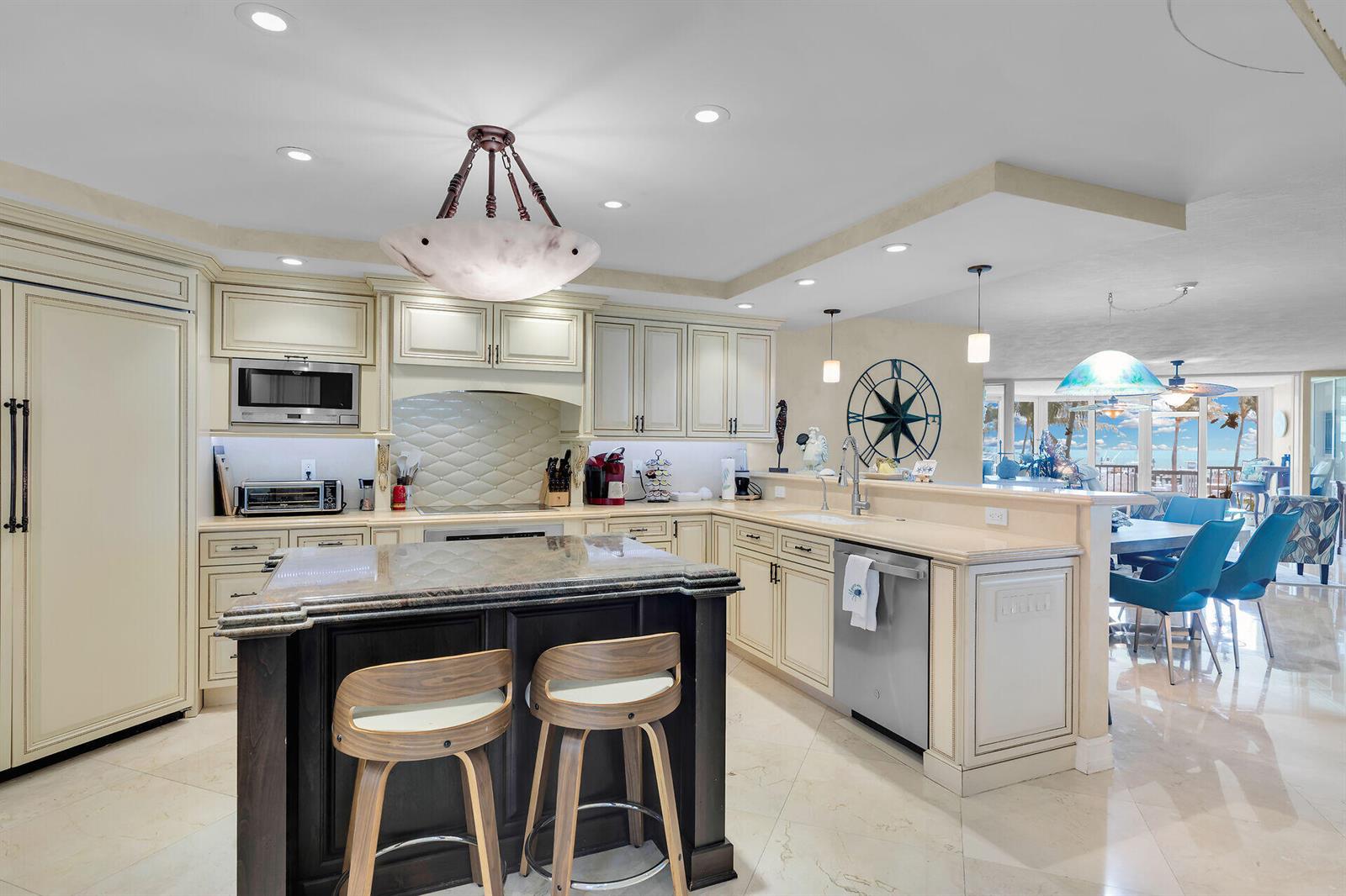 A kitchen with cream cabinetry, a dark wood island, granite countertops, and stainless steel appliances — 87851 Old Highway # M5, Islamorada FL 33036, ISLAMORADA, FL