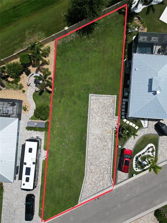 An aerial view shows a vacant residential lot with a paved driveway and grass — 8640 SW SAND CRANE CIRCLE LOT 48, ARCADIA, FL