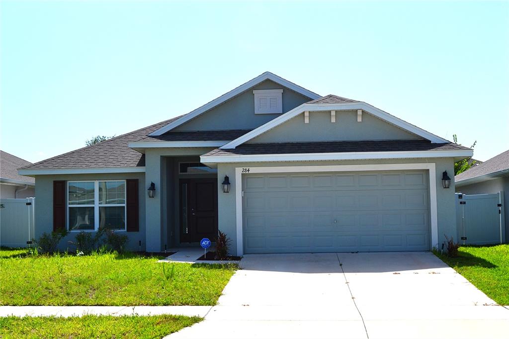 A single-story suburban house with a gray exterior, a two-car garage, and a front lawn — 284 CITRUS POINTE DRIVE, HAINES CITY, FL