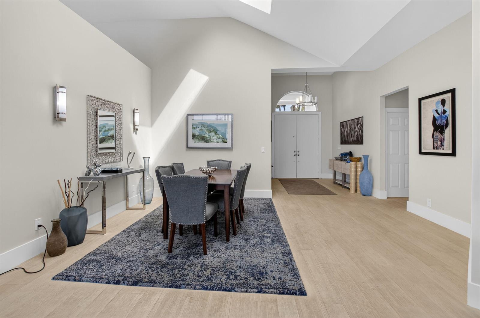 A dining area with a vaulted ceiling, gray upholstered chairs, and a blue patterned rug — 17320 Loch Lomond Way, Boca Raton FL 33496, BOCA RATON, FL