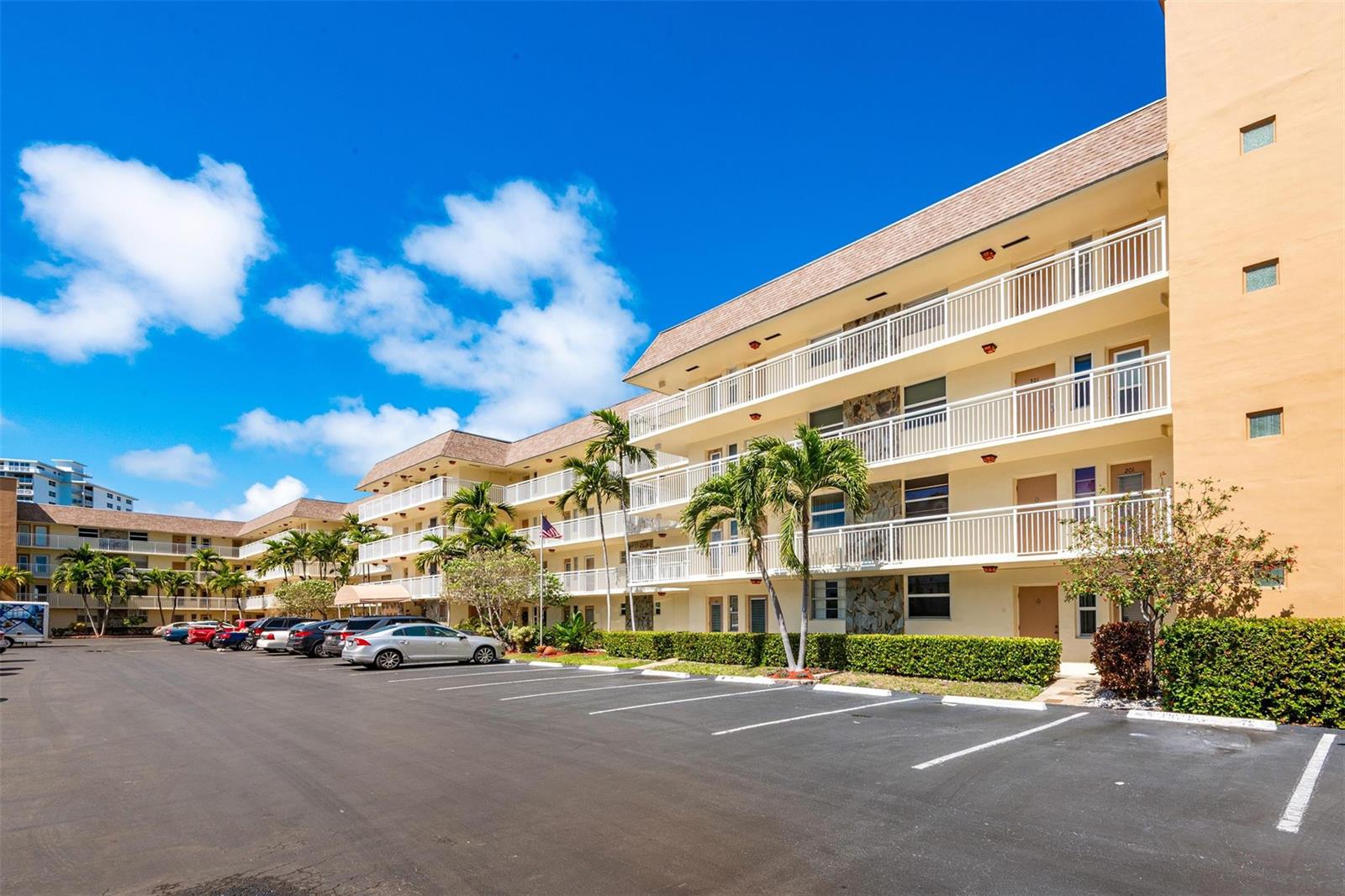 A multi-story apartment building with balconies and a parking lot under a blue sky — 1891 S Ocean Drive # 207, Hallandale Beach FL 33009, HALLANDALE BEACH, FL