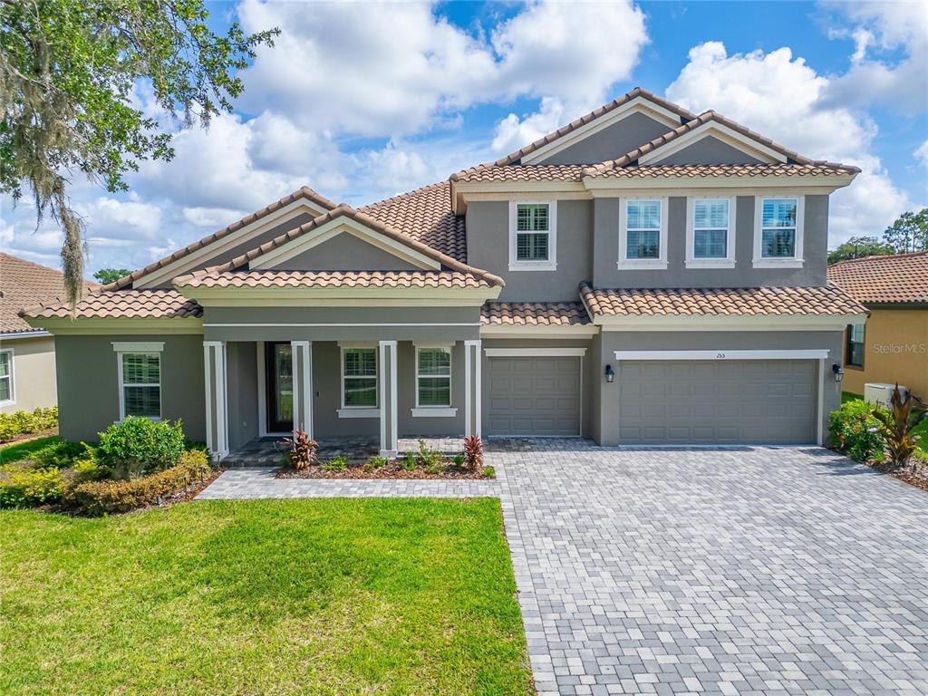 A two-story gray house with a tiled roof, a paved driveway, and a front porch — 155 SABAL BREEZE COURT, BRANDON, FL
