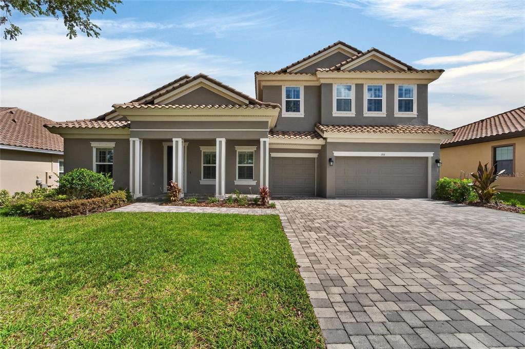 A two-story house with a gray exterior, tiled roof, and a paved driveway — 155 SABAL BREEZE COURT, BRANDON, FL