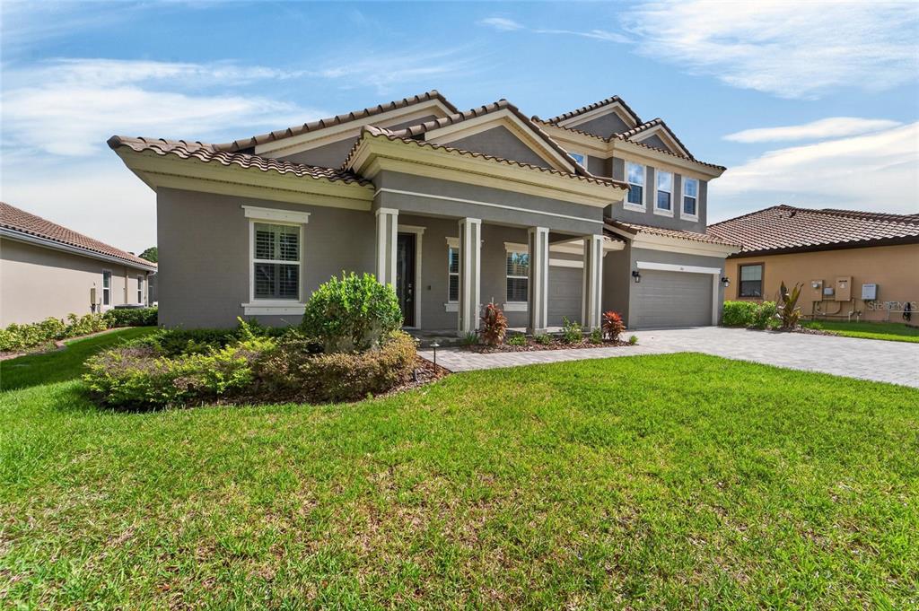 A two-story suburban house with a gray stucco exterior, tiled roof, and paved driveway — 155 SABAL BREEZE COURT, BRANDON, FL