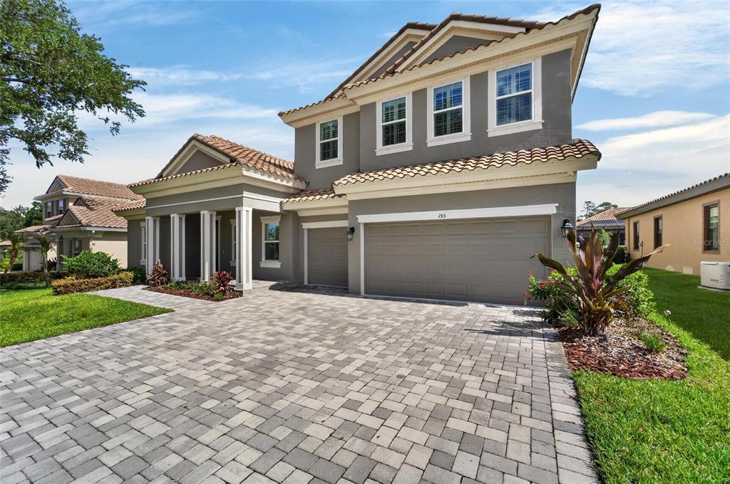 A two-story house with a gray exterior, tile roof, and a paved driveway — 155 SABAL BREEZE COURT, BRANDON, FL