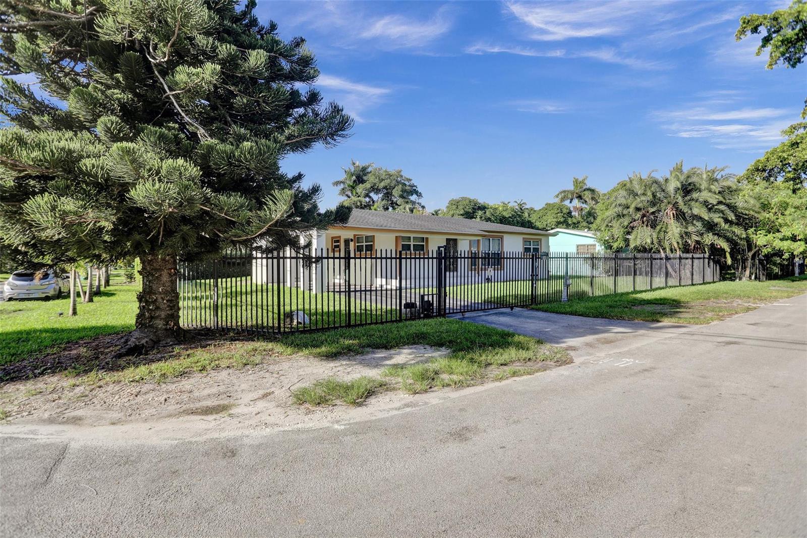 A single-story house with a fenced yard and a large pine tree in the front — 30 NE 139th Street, Miami FL 33161, MIAMI, FL