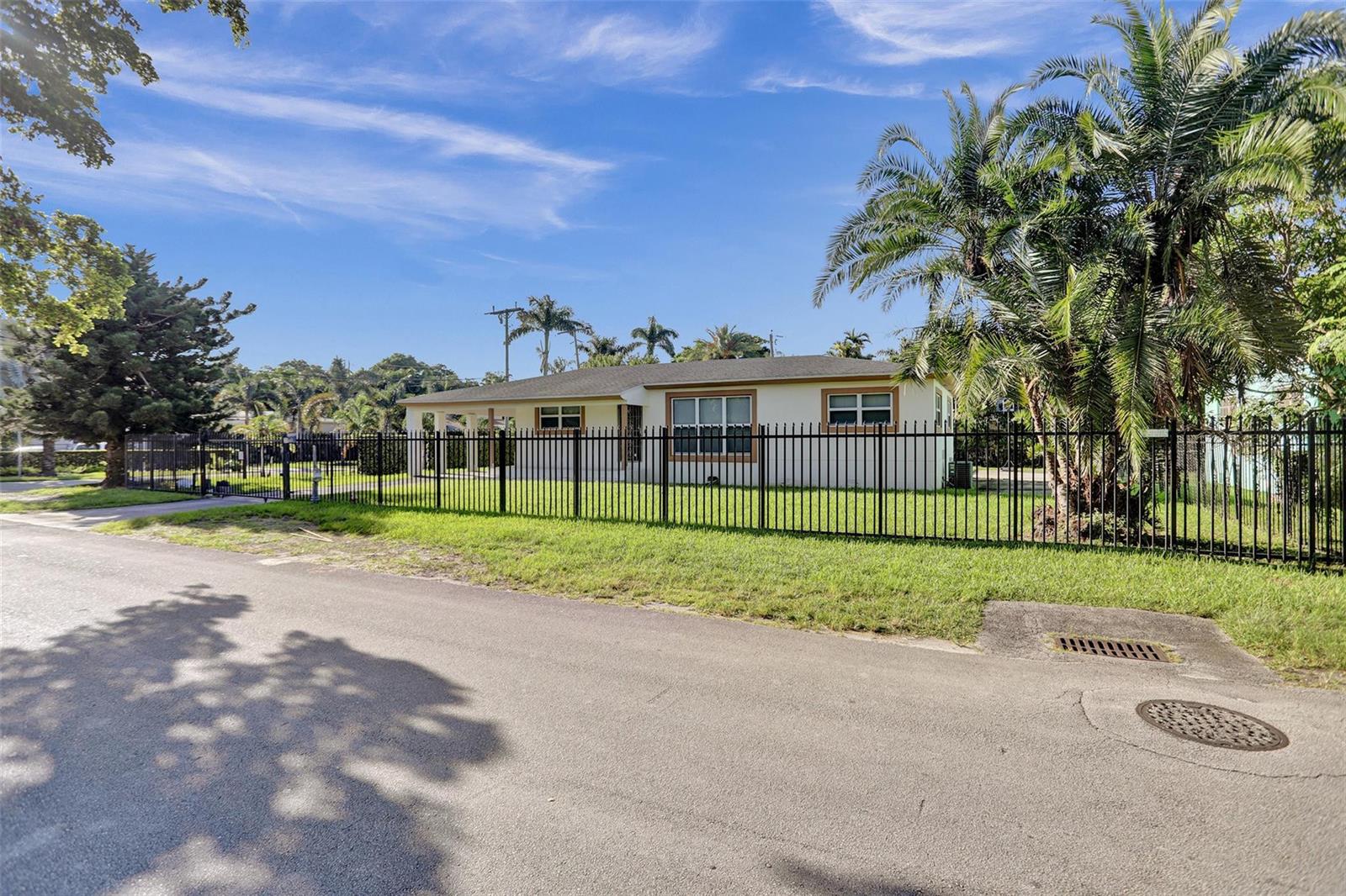 A single-story house with a fenced yard and palm trees sits along a paved street — 30 NE 139th Street, Miami FL 33161, MIAMI, FL