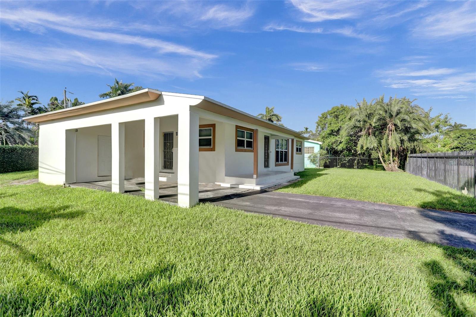 A white single-story house with a carport and a paved driveway sits on a lawn — 30 NE 139th Street, Miami FL 33161, MIAMI, FL