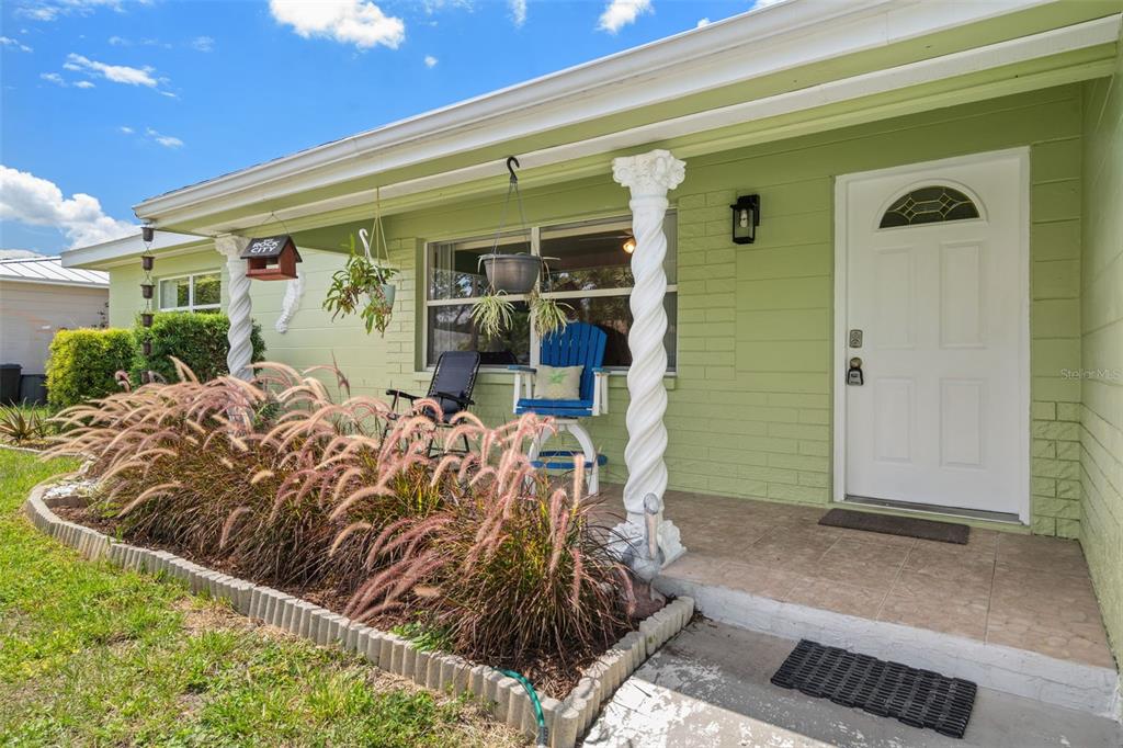 A light green house exterior features a front porch with white columns and a door — 9812 51ST AVENUE N, ST PETERSBURG, FL