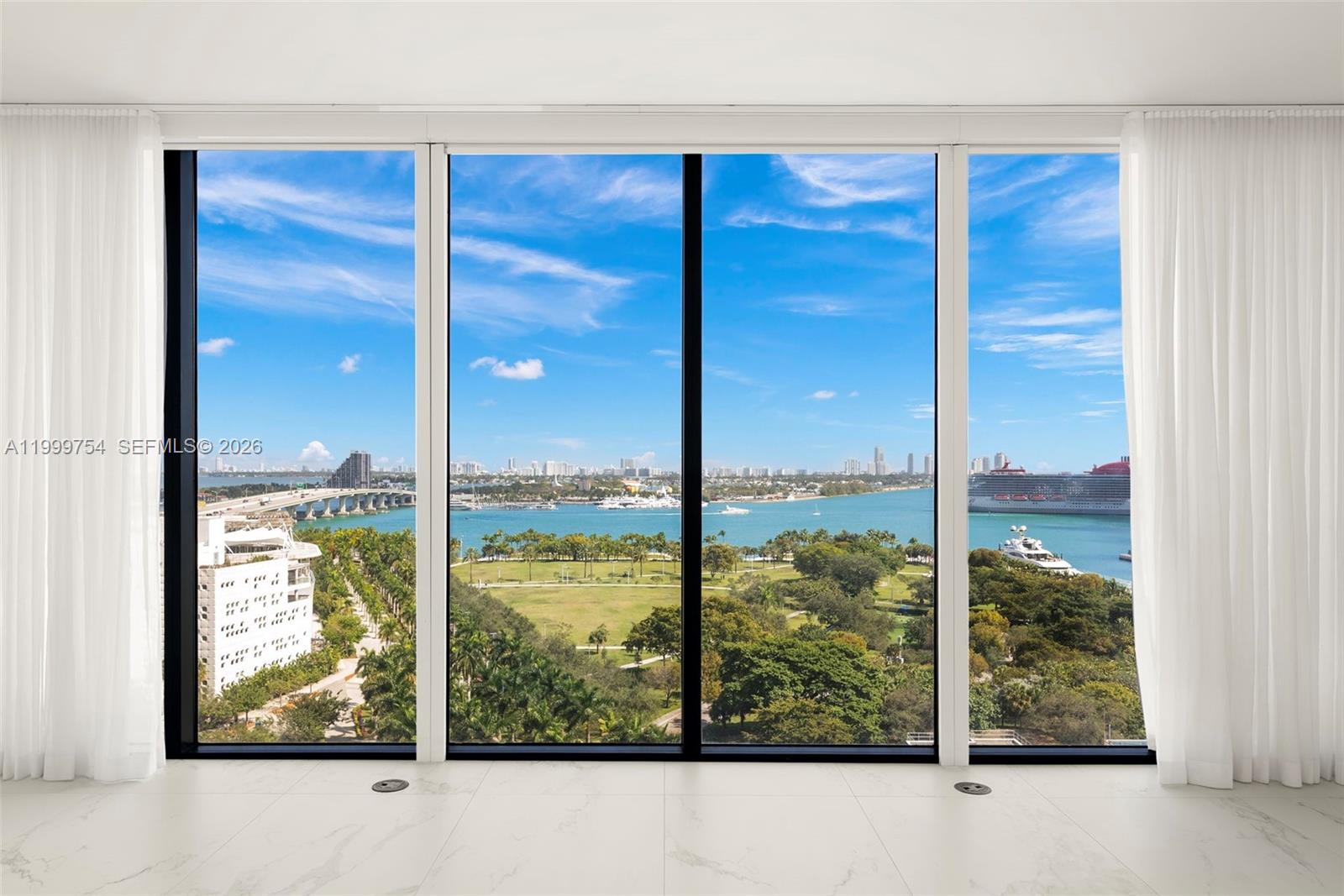 A room with floor-to-ceiling windows overlooks a bay, a park, and a cruise ship — 1000 Biscayne Blvd # 1201, Miami FL 33132, MIAMI, FL