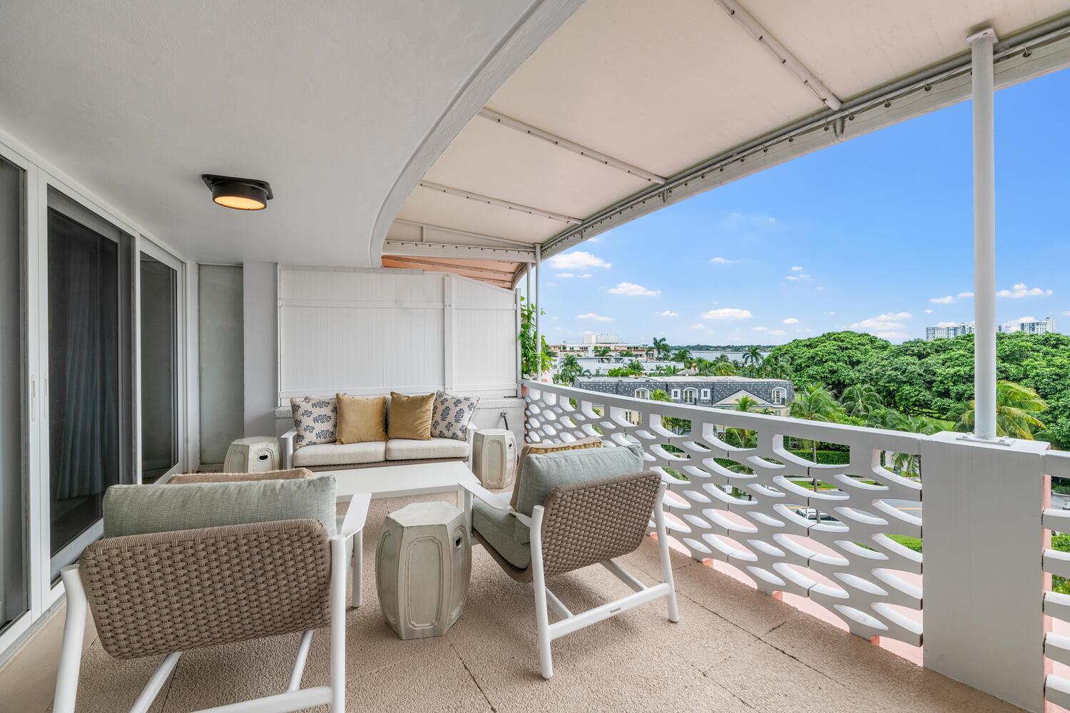 A balcony features outdoor furniture, a patterned white railing, and a view of trees — 315 S Lake Drive # C, Palm Beach FL 33480, PALM BEACH, FL