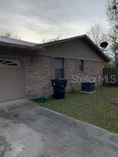 A brick house exterior with a garage, a driveway, and an outdoor air conditioning unit — 1100 WILSON ROAD, STARKE, FL