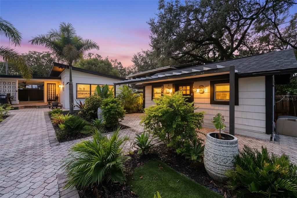 A paved walkway leads to the entrance of a white house with lush landscaping — 308 E HOLLYWOOD STREET, TAMPA, FL