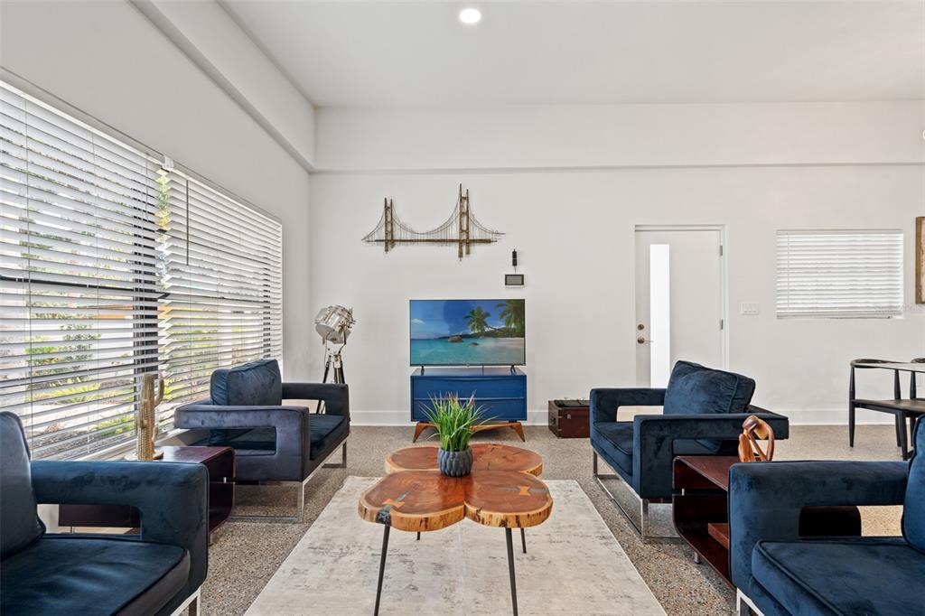 A living room features blue velvet armchairs, a wooden coffee table, and a television console — 308 E HOLLYWOOD STREET, TAMPA, FL