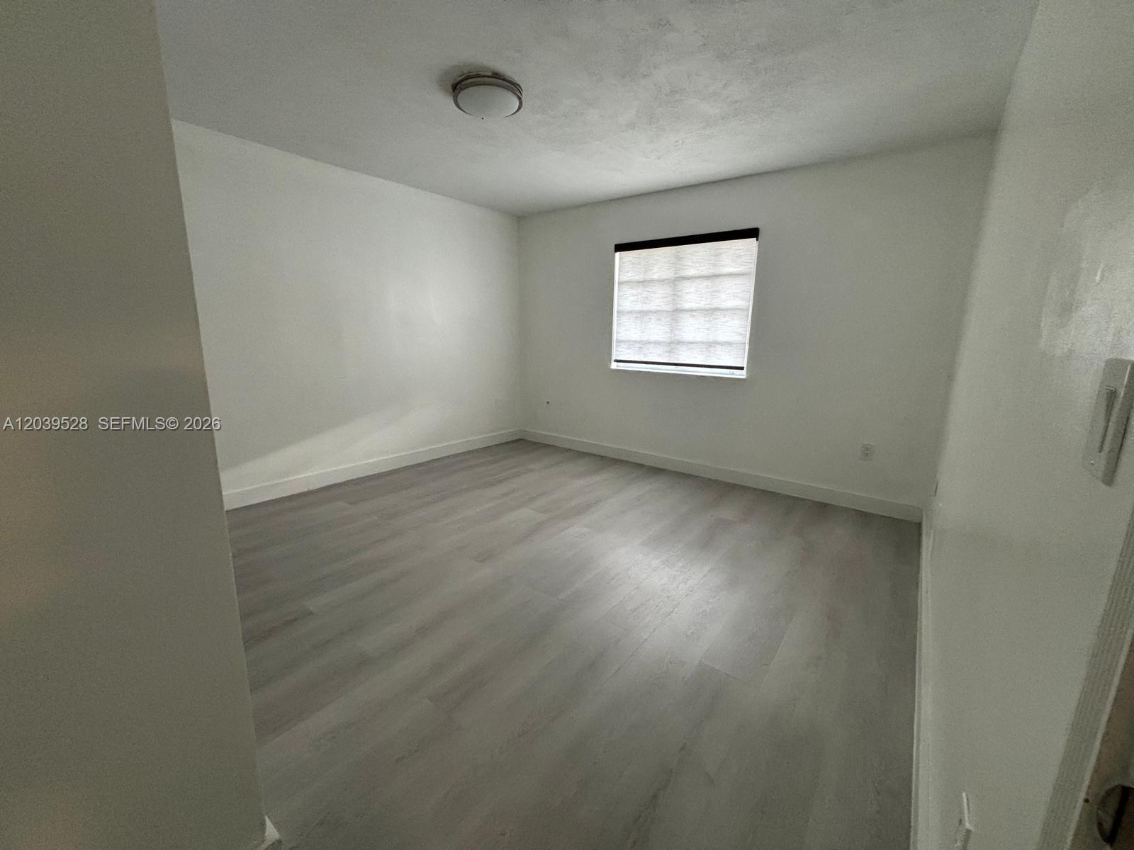 An empty bedroom features white walls, light gray wood-look flooring, and a single window — 2150 SW 76th Ct, Miami FL 33155, MIAMI, FL