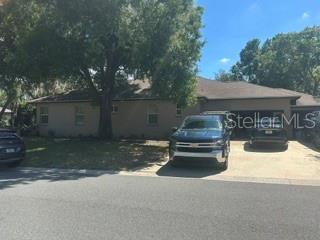 A single-story house with a tan exterior and a two-car garage sits on a lot — 2702 CLUBHOUSE DRIVE, PLANT CITY, FL