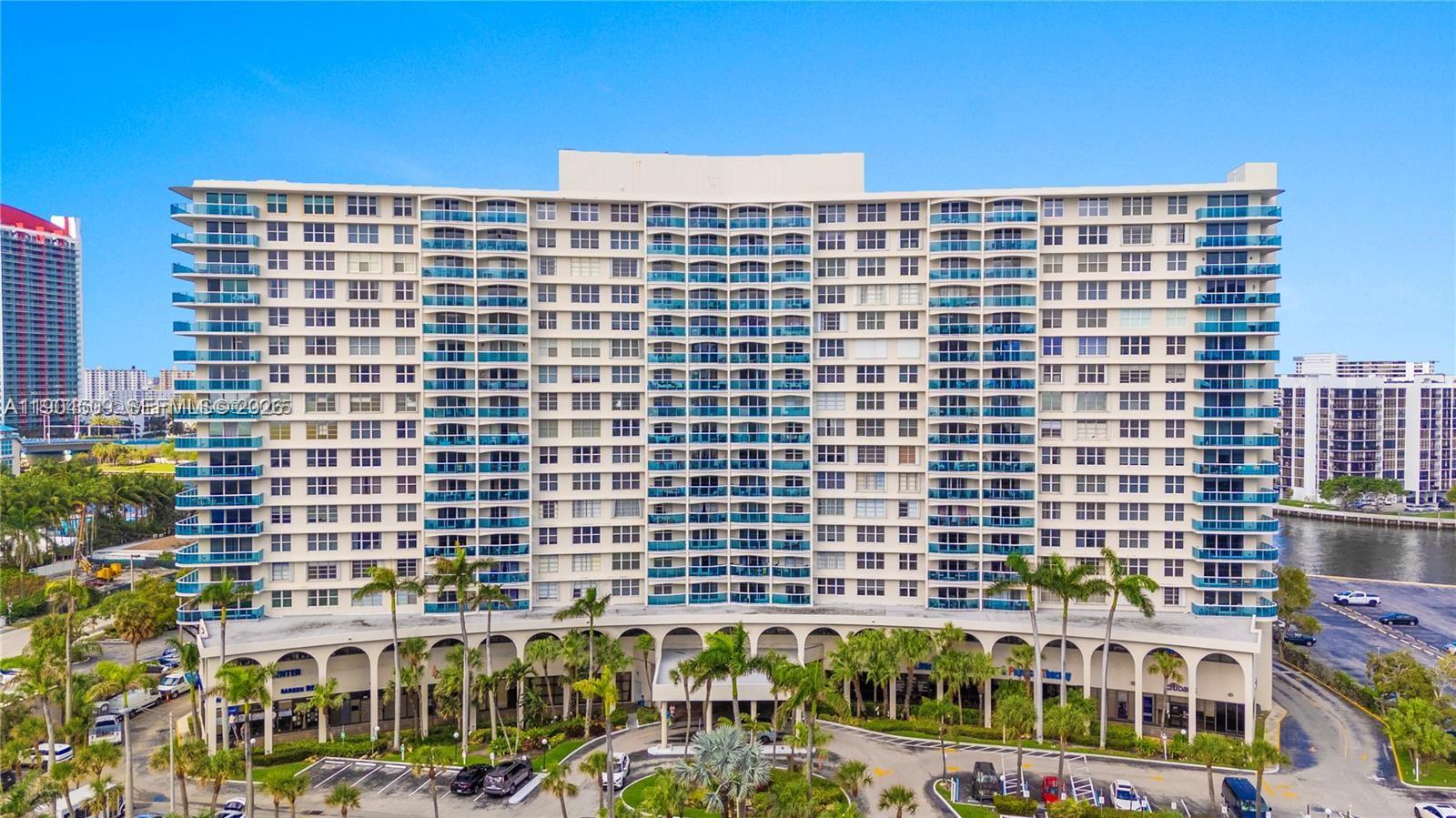An exterior view of a tall, multi-story residential building with balconies and a ground-level arcade — 3800 S Ocean Dr, Hollywood FL 33019, HOLLYWOOD, FL