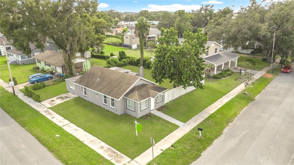 An aerial view shows a gray single-story house with a brown roof on a corner lot — 1600 ROOSEVELT AVENUE, ORLANDO, FL