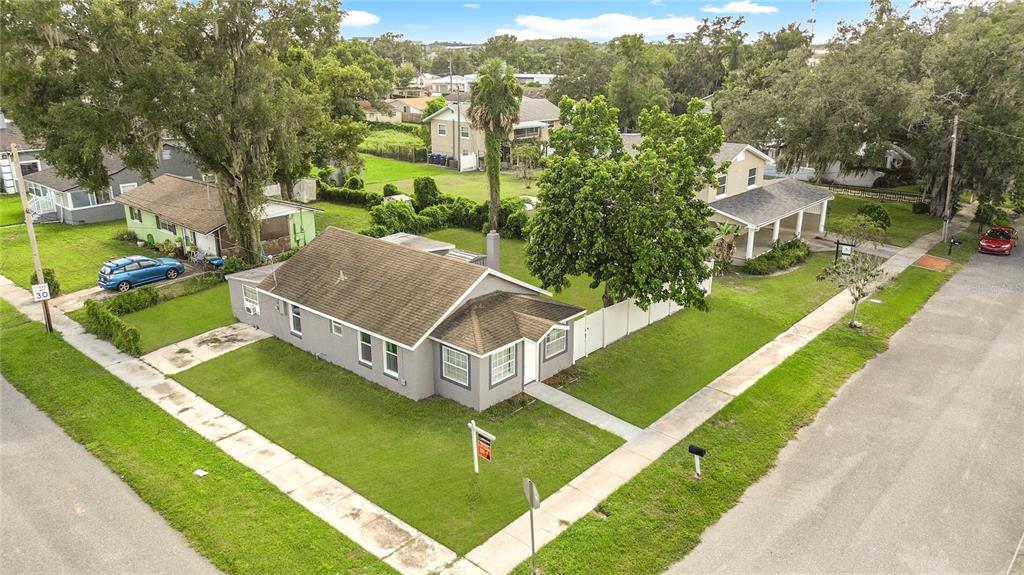 An aerial view shows a gray single-story house with a brown roof on a corner lot — 1600 ROOSEVELT AVENUE, ORLANDO, FL