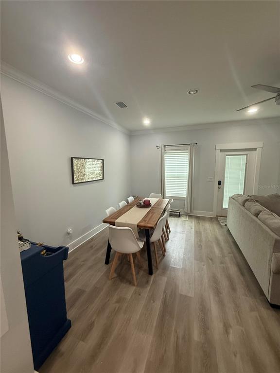A dining area features a wooden table with white chairs, light flooring, and a sofa — 105 PENTECOST WAY, FORT WALTON BEACH, FL