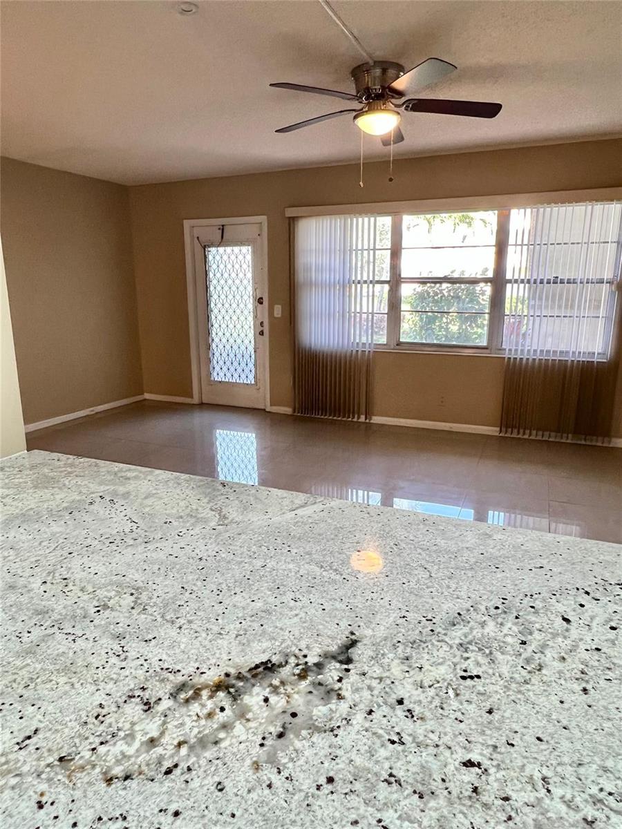 A view from a granite countertop looking toward a living area with a ceiling fan — 517 Mansfield M # 517, Boca Raton FL 33434, BOCA RATON, FL