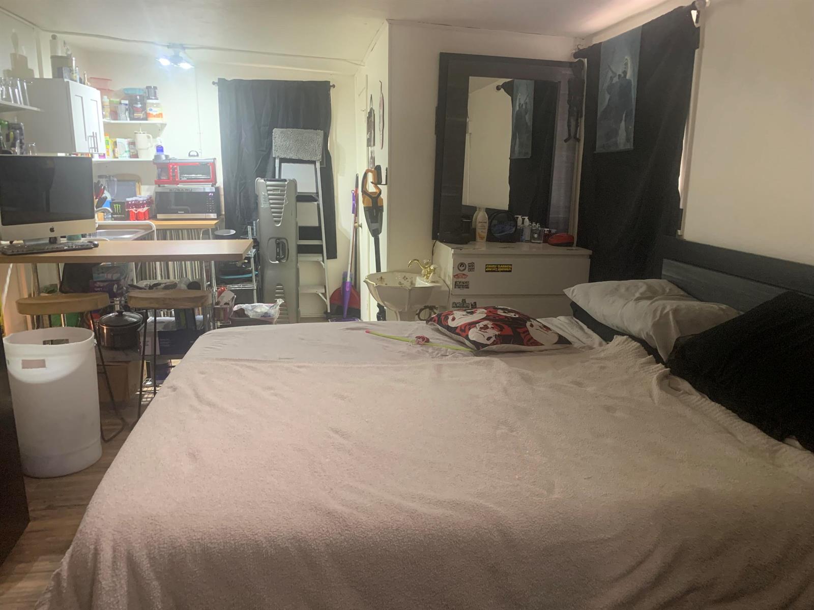 A studio apartment featuring a bed, a small kitchen area, and a vanity sink — 400 W Perry Street # d, Lantana FL 33462, LANTANA, FL