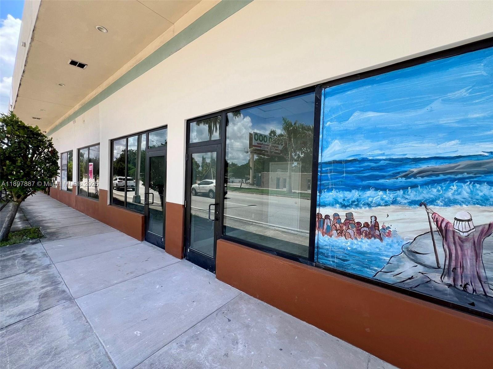 The exterior of a commercial building features glass storefronts and a mural of a beach — 9150 NW 22nd Ave, Miami FL 33147, MIAMI, FL