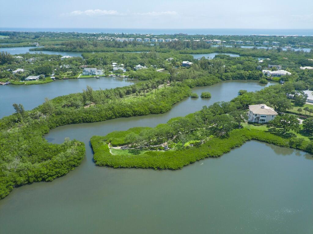 An aerial view shows waterfront homes nestled among dense green mangroves and winding waterways — 2660 Riverview Court, Vero Beach FL 32963, VERO BEACH, FL
