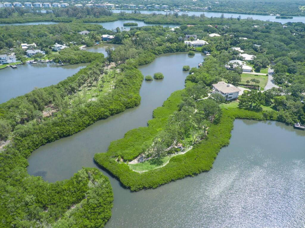 An aerial view shows a waterfront home surrounded by dense mangroves and a winding waterway — 2660 Riverview Court, Vero Beach FL 32963, VERO BEACH, FL