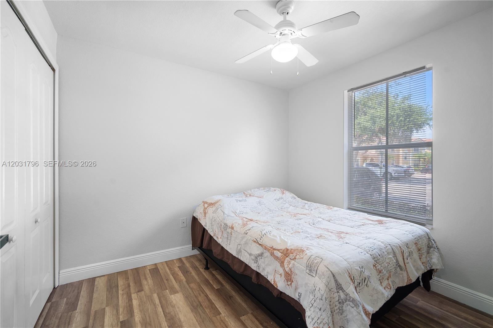 A bedroom with wood-look flooring, a ceiling fan, and a bed positioned by a window — 3073 SW 128th Ave # 109, Miramar FL 33027, MIRAMAR, FL