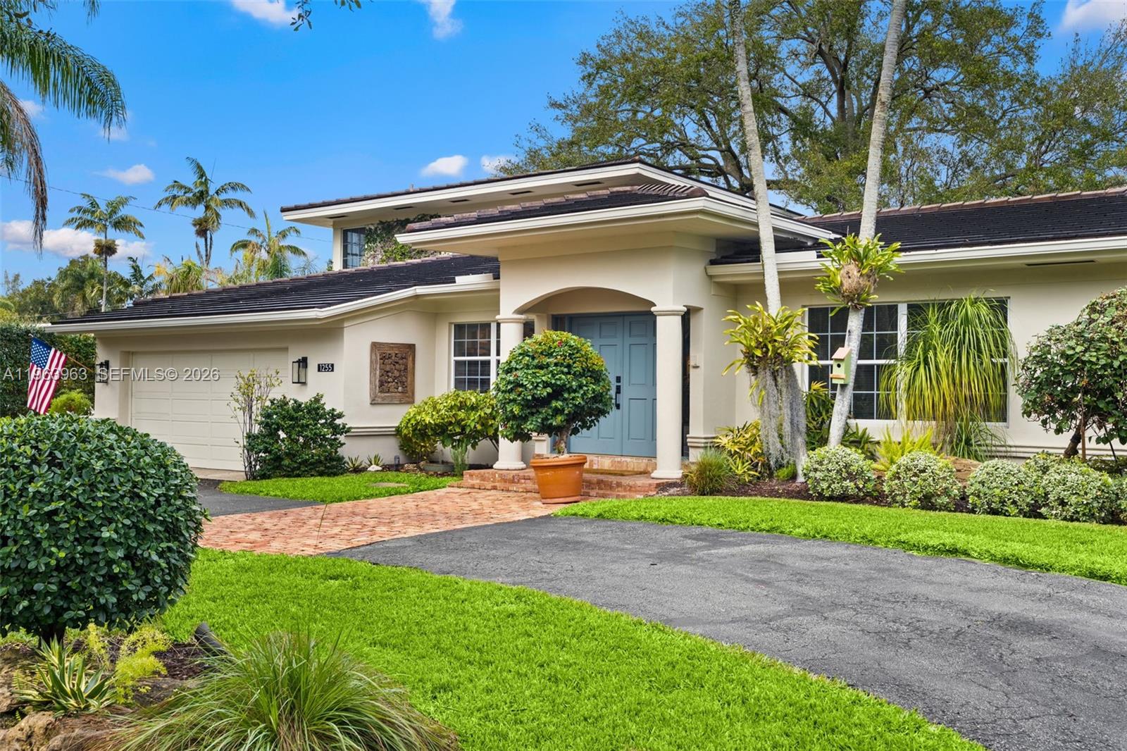 A single-story house features a brick walkway, blue double front doors, and a paved driveway — 1255 Algardi Ave, Coral Gables FL 33146, CORAL GABLES, FL