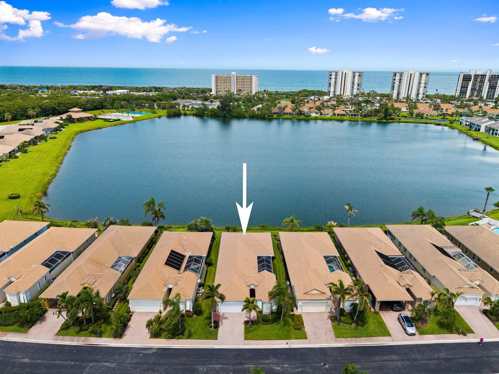 An aerial view shows a row of suburban houses situated along a large lake — 3320 Caracal Drive, Fort Pierce FL 34949, FORT PIERCE, FL