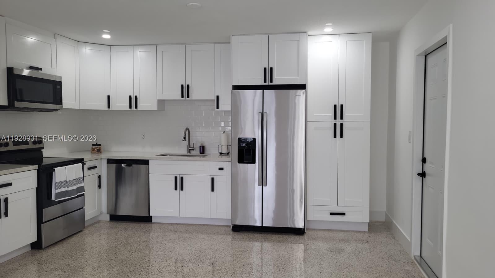 A kitchen with white cabinets, stainless steel appliances, and light-colored speckled flooring — 9228 SW 37th St # 9228, Miami FL 33165, MIAMI, FL