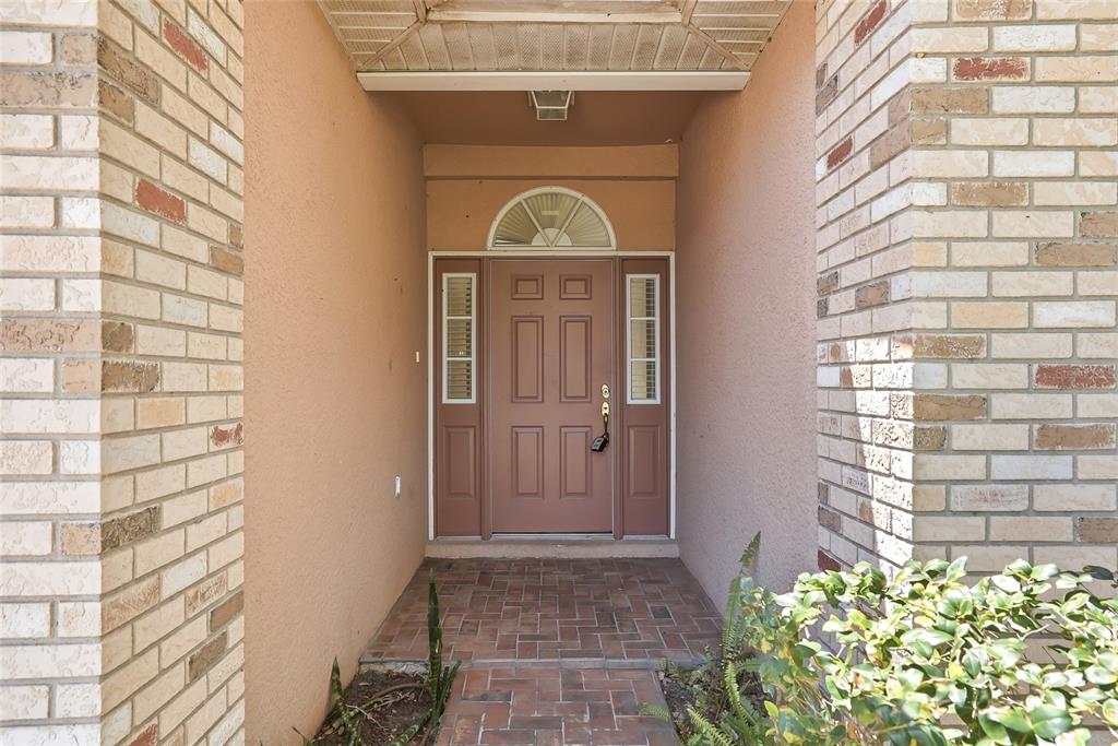 A front entryway features a brown door with sidelights and a brick-paved porch — 1934 OLD SAWMILL ROAD, BRANDON, FL