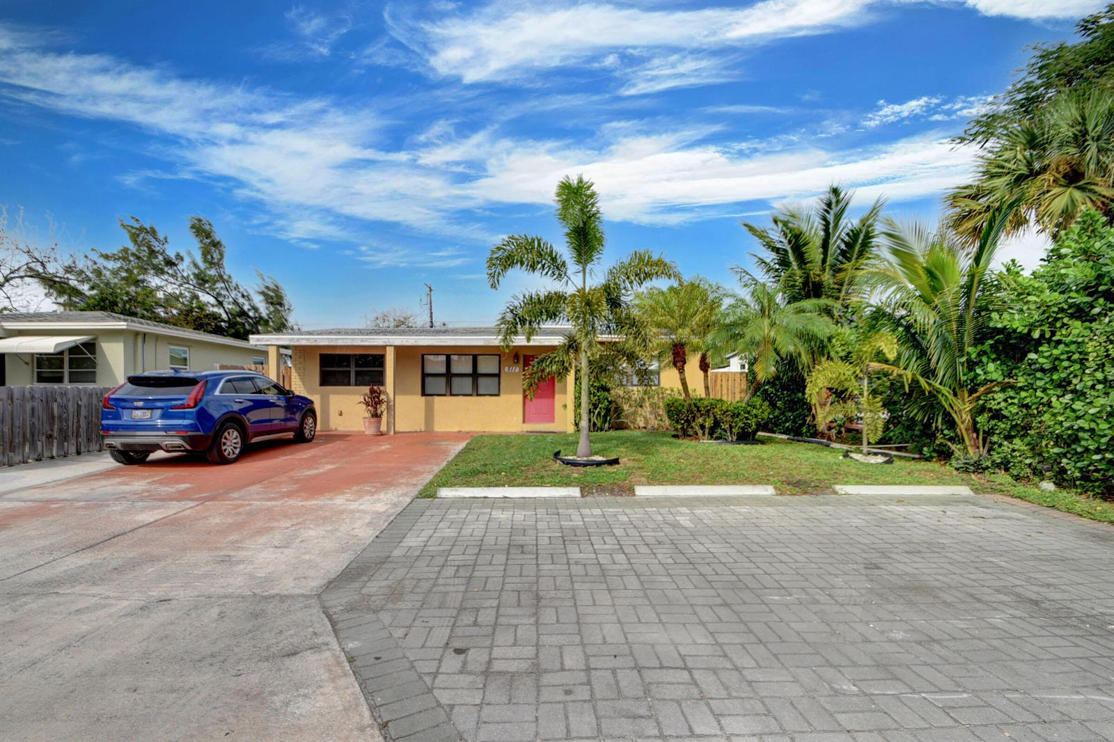 A single-story yellow house with a red door, a blue SUV, and a paved driveway — 511 Minnesota Street, Lantana FL 33462, LANTANA, FL